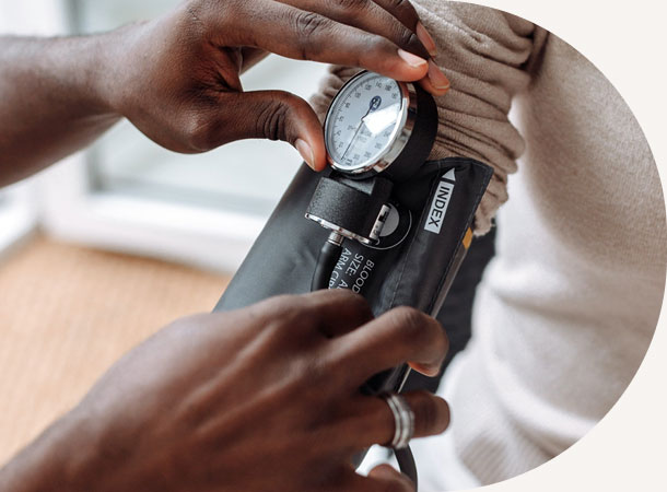 Close up of hands on a blood pressure cuff on a patient