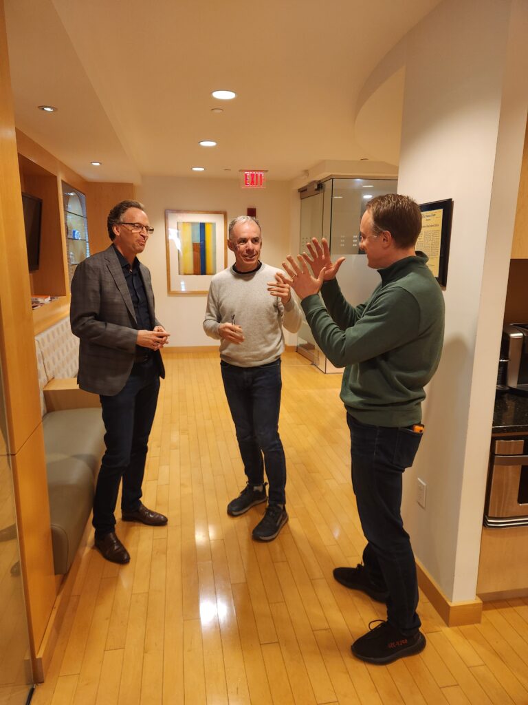 Three men having a conversation in the 406 hallway