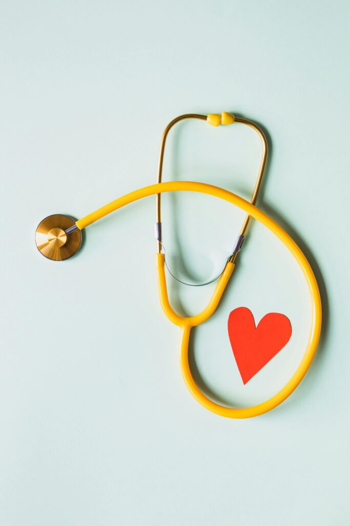 stethoscope on a table looped around a cutout heart