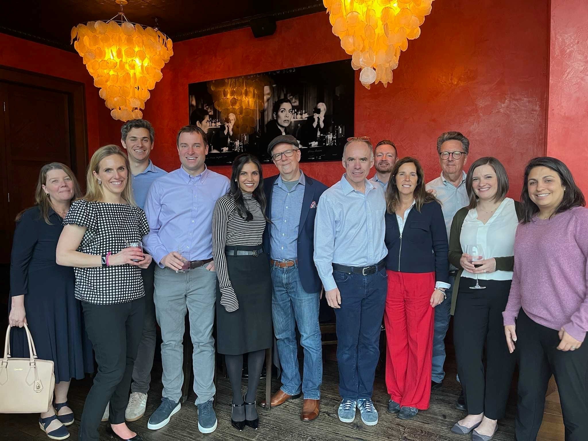 4 o 6 leaders and a large team pose at an event