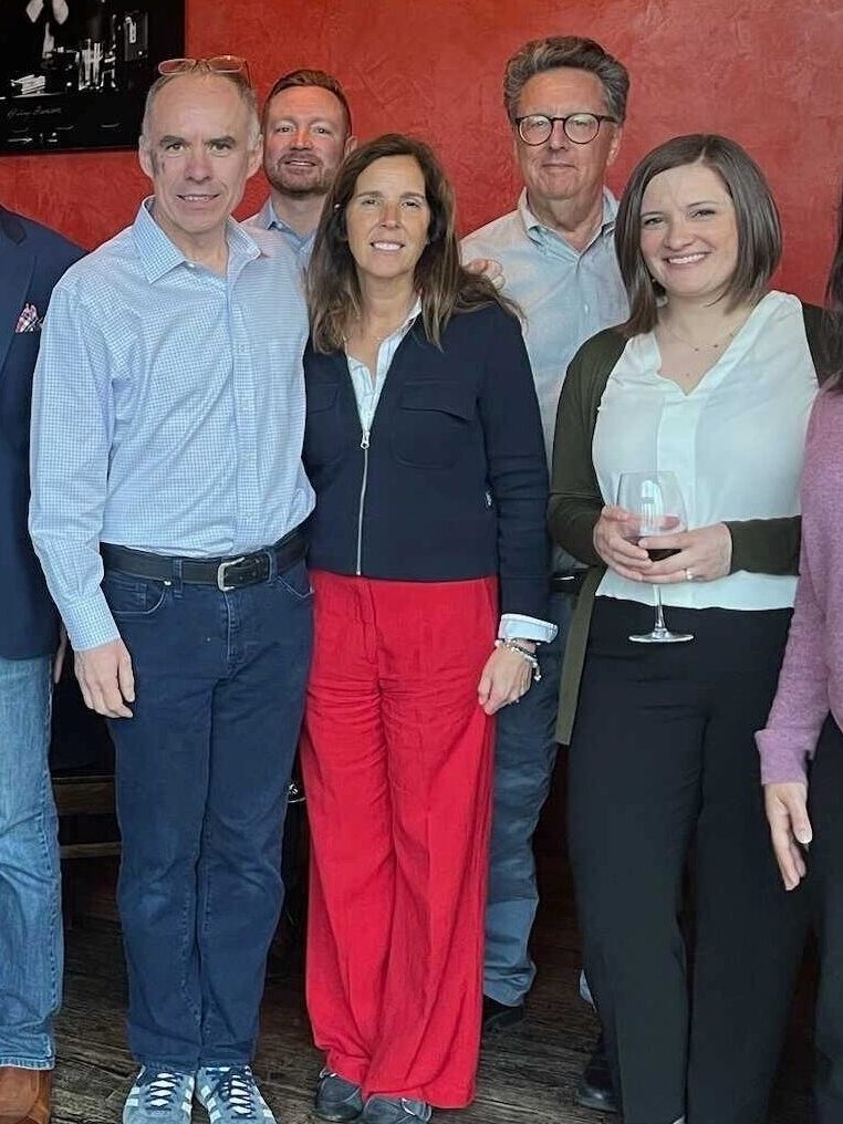 4 o 6 leaders and a large team pose at an event